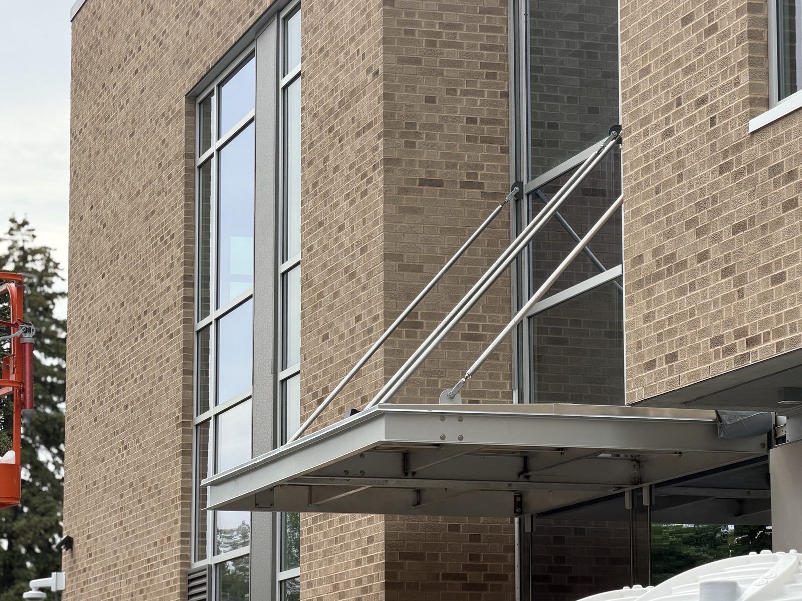 The finished aluminum canopy hung from the curtain wall on tie rods